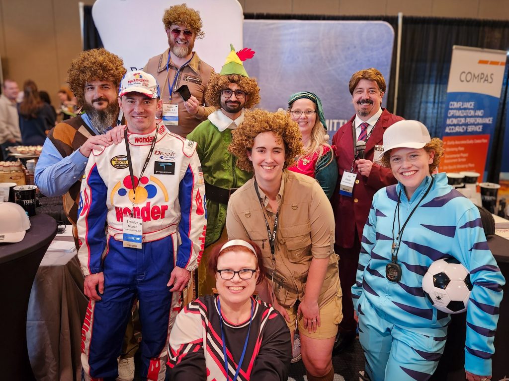Tora staff dressed up as Will Ferrell movie characters at a professional expo event.