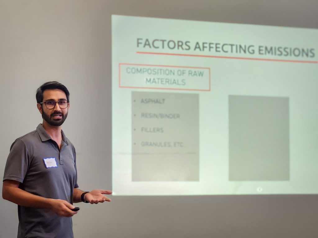 Principal Advisor Sanjam Singh presenting in front of a projected slide about materials processing emissions.
